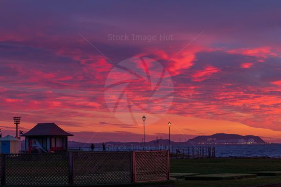 Beautifully lit clouds as sun begins to set over seaside town