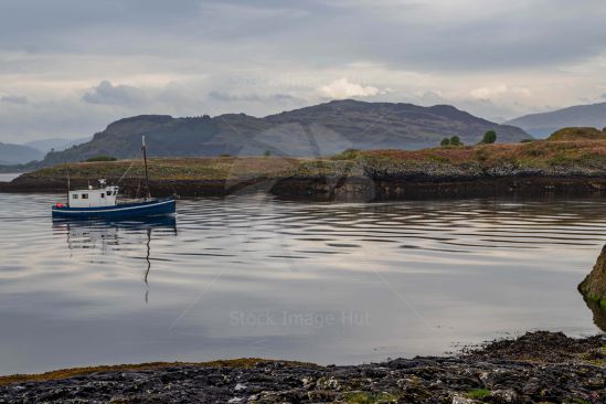 A small fishing boat heading back to harbour just off Oban, Scotland