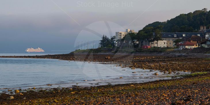 The Celebrity Silhouette cruise ship sailing past small seaside town as she heads for port