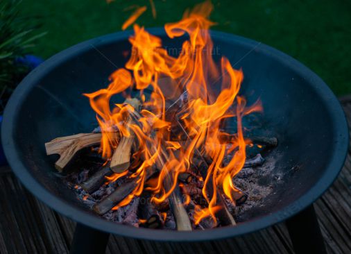 Burning logs and sticks in outdoor firepit