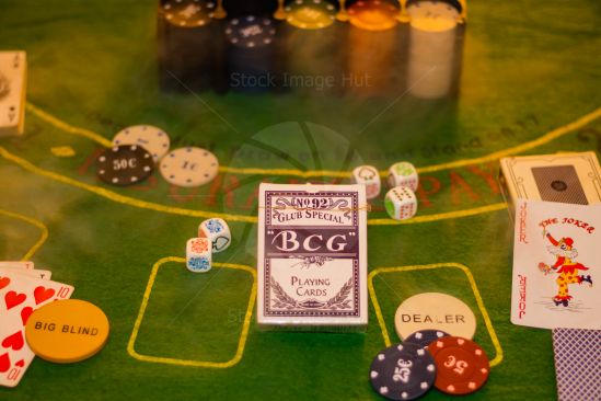 Game of poker with chips and playing cards sitting on green baize image