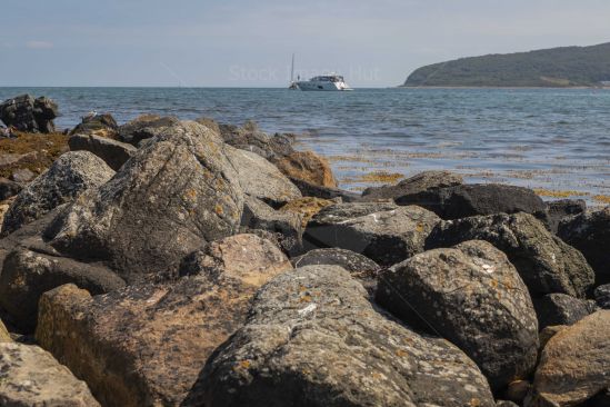 View from rugged coastline out to sea with cruiser in distance