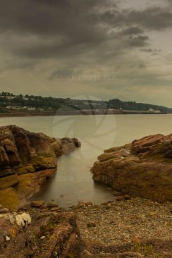 Looking from edge of beach across to distant ferry terminal at Wemyss bay, Scotland