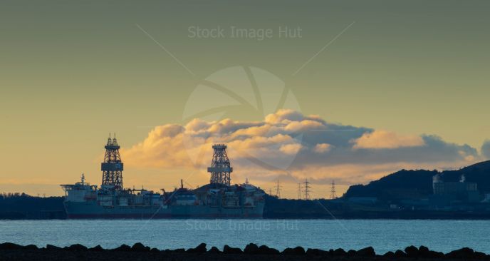 Two docked drilling ships  at sunrise