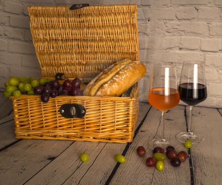 Picnic basket  with grapes and bread with glasses of red and rose wine